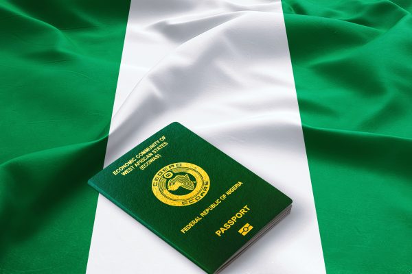 Official passport of Nigeria on the top of a satin Nigerian flag ,The Republic of Nigeria passport,Green Ecowas passport The Republic of Nigeria passport issued to Nigerian citizens to travel outside of Nigeria